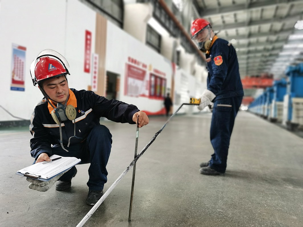 图为云铝淯鑫员工在进行电解槽铝水平与电解质水平测定。沈琼 摄 足球一世666814